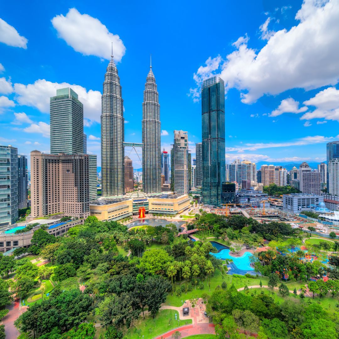 The Kuala Lumpur skyline at dusk, with the Petronas Towers rising above the city, the capital of Malaysia and a Southeast Asian business hub for private jet charter.